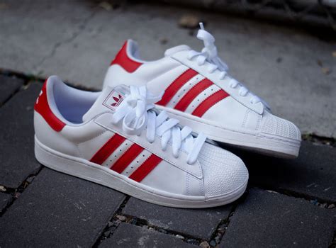 white adidas with red stripes.